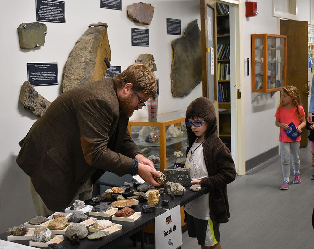Student teaches kid about fossils at Earth Day Event